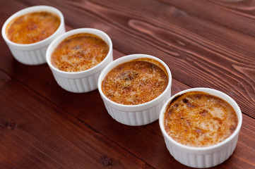 Creme brulee in a white bowl with sugar crust. Studio photography. country style.