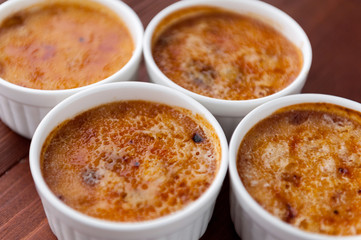 Creme brulee in a white bowl with sugar crust. Studio photography. country style.