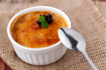 Creme brulee in a white bowl with sugar crust. Studio photography. country style.