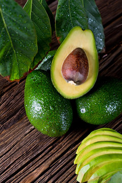 Fresh organic avocado on old wooden table. The composition of pictures in close-up.