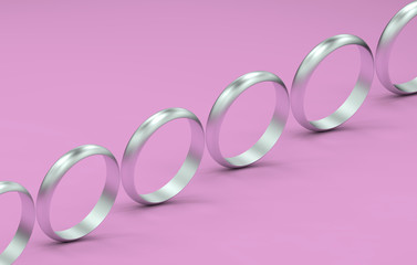3d render of silver rings in a row on a pink background