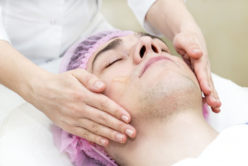 Fototapeta na wymiar Man in the mask cosmetic procedure in spa salon