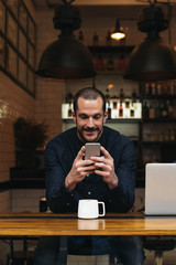 Businessman using his mobile in the Coffee Shop.
