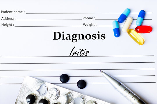 Iritis -  Diagnosis written on a piece of white paper with medication and Pills