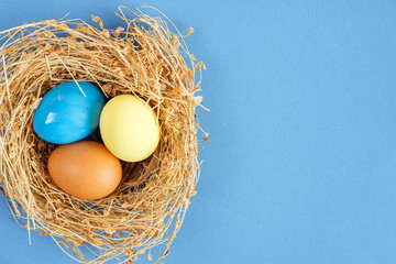 Easter eggs in nest on rustic wooden background, selective focus image. Happy Easter Card - space for text 