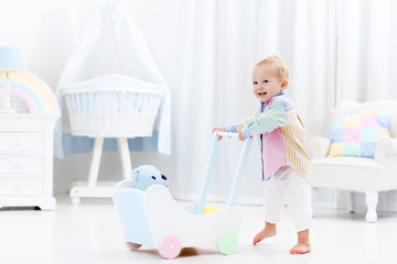 Baby with push walker in white bedroom