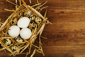 Chicken and quail eggs on the wooden table. Easter background