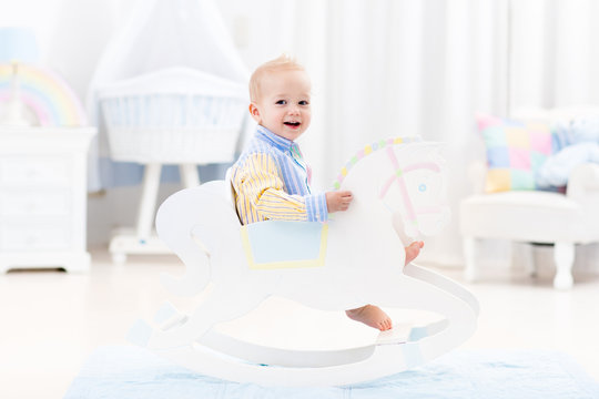 Baby boy in rocking horse toy