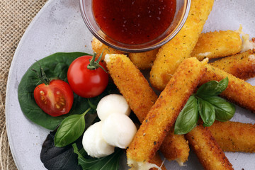 Breaded mozzarella cheese sticks with tomato ketchup and bbq sauce