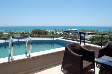 View of the small pool and the beach from the balcony of  Turkish hotel.