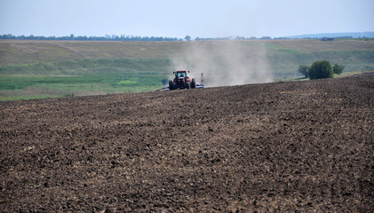 Obraz premium Powerful tractor sows Field