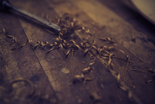 close up on a wood carving tool next to shavings