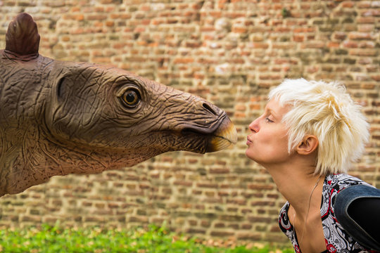 Belgrade, Serbia - October 05, 2014: Young woman kissing dinosaurs in the dino park, Belgrade, Serbia
