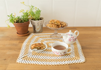 Desayuno a base de hojaldre de manzana y té sobre una mesa de madera