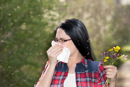 Girl having allergy and sneezing in tissue