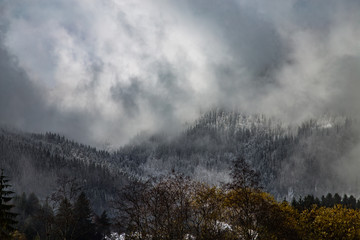 Mountains covered with snow and surrounded by clouds