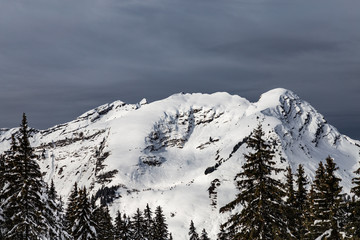 Mountains covered with snow and surrounded by clouds