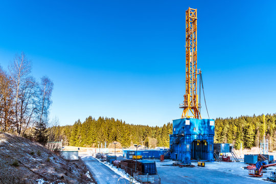 Fracking-Bohrturm in einer Waldlichtung unter blauem Himmel