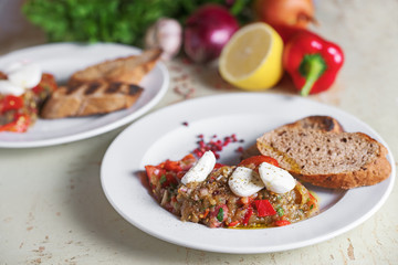 Italian appetizer of eggplant with mozzarella cheese. On vegetables background