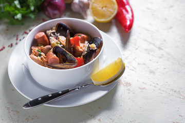 Paella in white plate with saffron rice, peas, shrimps, mussels, squid, meat. Seafood paella, traditional spanish dish.