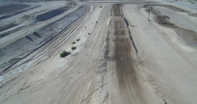 MotorCross rider on the track making a jump, aerial view from a drone