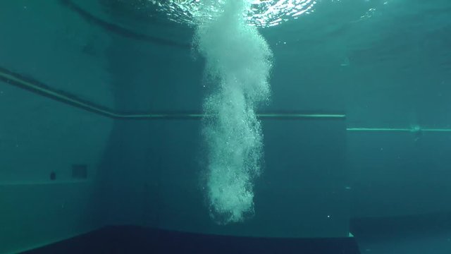 Diving (Jumping into the water), female athlete entering the water, the cloud of air bubbles, Underwater.
