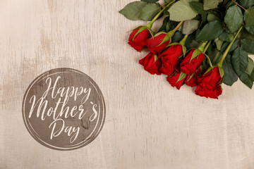 Red roses on wood vintage background. Happy mothers day. Concept for romantic love design. Fresh natural flowers. Wooden grunge board.