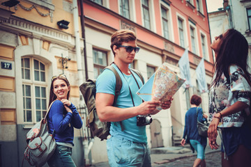Obraz na płótnie Canvas Multi ethnic friends tourists with map in old city