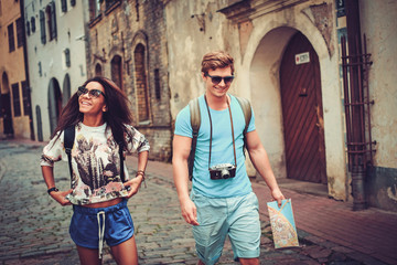 Multi ethnic tourists couple with map in old city