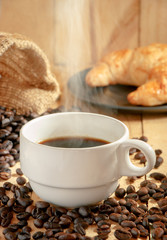 Coffee cup and coffee beans on wood table