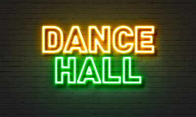 Dance hall neon sign on brick wall background.