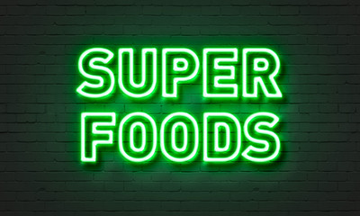 Super foods neon sign on brick wall background.