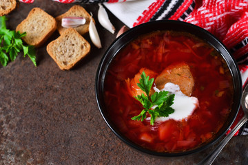 Homemade borsch with meat and sour cream on grunge background