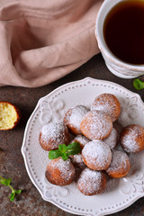 Homemade donuts with powdered sugar for breakfast on the old grunge background
