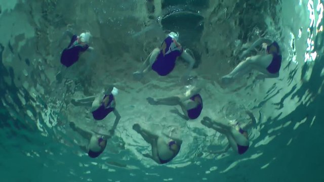 Synchronized swimming, team training, underwater view.
