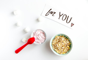 concept kid breakfast with yogurt top view white background