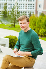 A young man working with laptop in the Park.