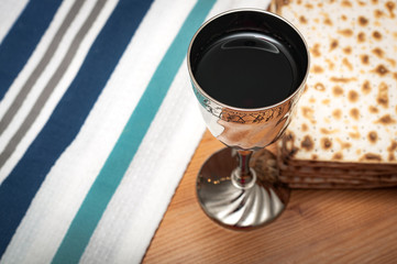 Judaism and religious jewish holiday with matzos (unleavened flatbread), cup of wine, and a white...
