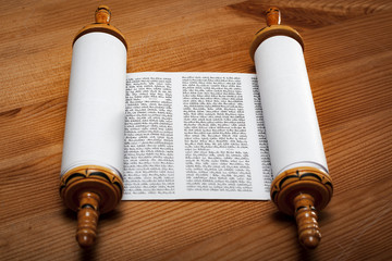 Judaism and religious text concept with a open Torah on wooden background