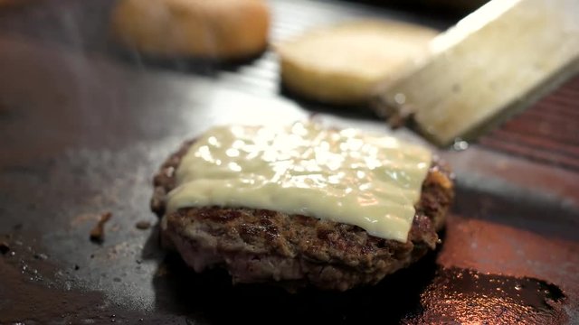 Patty with cheese. Cooked meat on oven pan. Cheddar and beef.