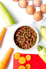 Set of animal dry food, vegetables and eggs on kitchen top view