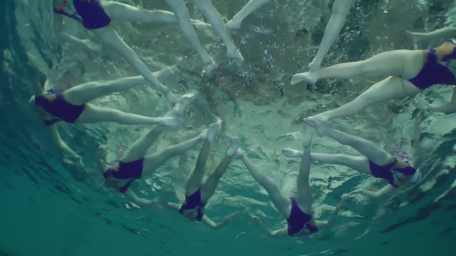 Synchronized swimming, team training, underwater view.
