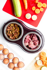food for pets with meat and eggs on kitchen background top view