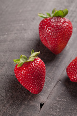 Local fresh California strawberries on a dark wooden background macro shot