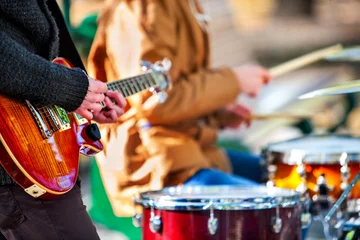 Foto op Aluminium Festival music band. Hands playing on percussion instruments in city park . Drums with sticks closeup. Body part of male musicians. Sharpen is guitar and man hand. © Gennadiy Poznyakov