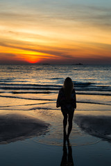 Fototapeta premium Girl looking at the sunset in Pantai Tengah beach, Langkawi, Malaysia.