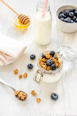 Fitness breakfast with granola, milk and honey on white background