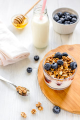 Fitness breakfast with granola, milk and honey on white background