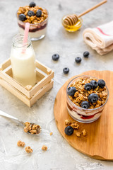 Morning granola with yogurt, honey and berries on white table