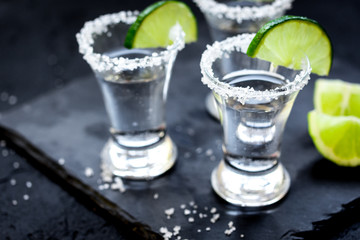 Set for tequila party with lime and salt on black background